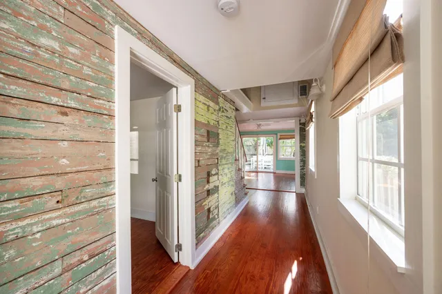 a view of a hallway with wooden floor and staircase