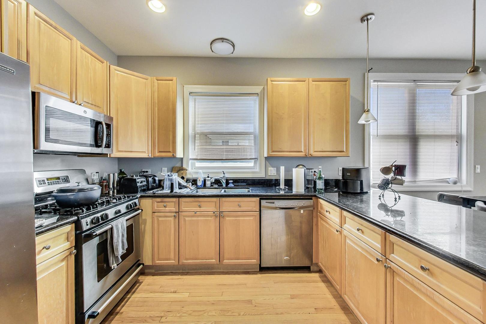 1330 West Fletcher Street, Unit 1 Chicago, IL 60657 - Photo 14 of 42 a kitchen with stainless steel appliances a stove sink microwave and cabinets