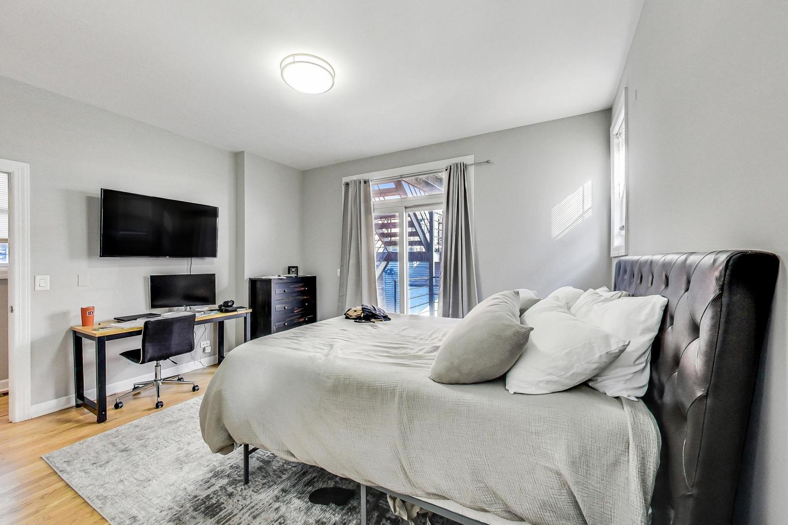 1330 West Fletcher Street, Unit 1 Chicago, IL 60657 - Photo 17 of 42 a bedroom with a bed and a flat screen tv