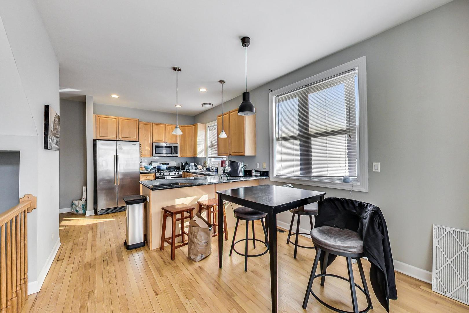 1330 West Fletcher Street, Unit 1 Chicago, IL 60657 - Photo 10 of 42 a kitchen with stainless steel appliances granite countertop table chairs refrigerator and sink