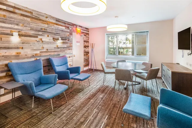 a living room with furniture a flat screen tv and a large window