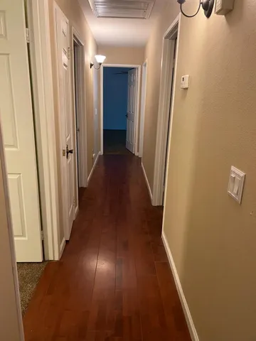 a view of a hallway with wooden floor
