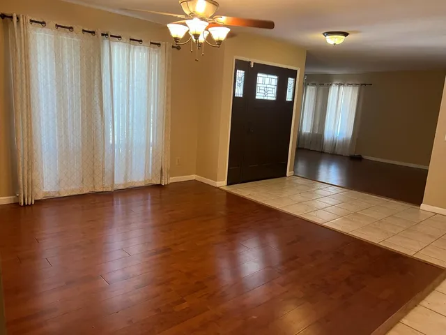 a view of a livingroom with wooden floor and stairs