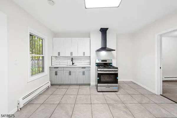 a kitchen with a stove a sink and a window