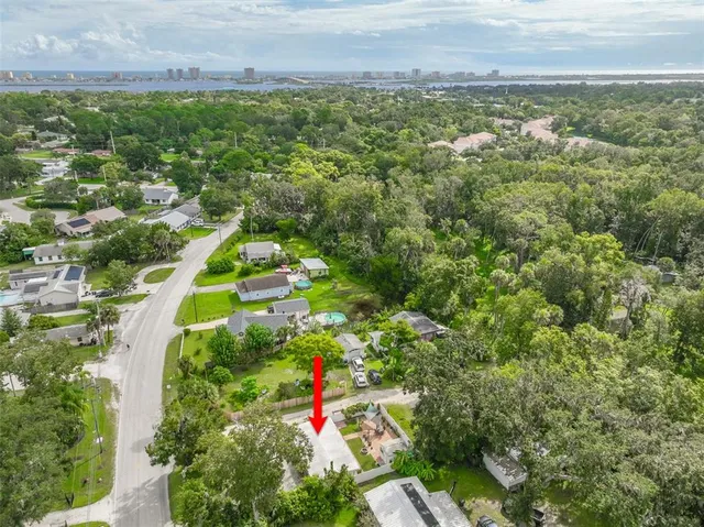 an aerial view of residential houses with outdoor space and trees