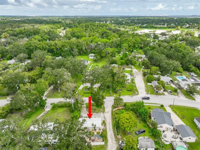 an aerial view of residential houses with outdoor space and trees