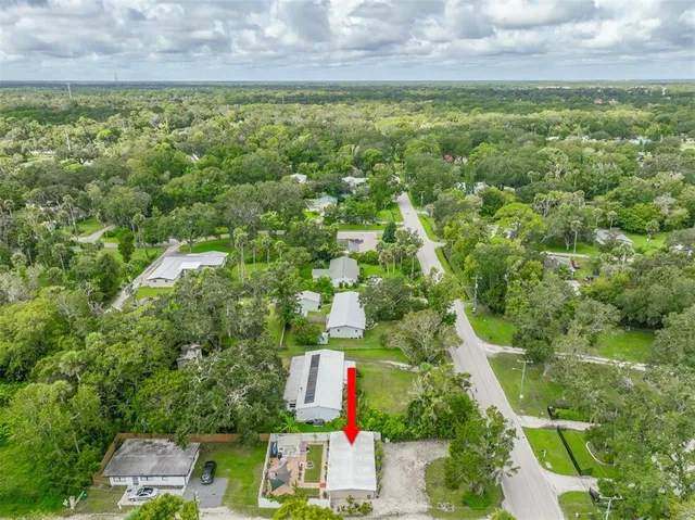 an aerial view of residential houses with outdoor space and trees