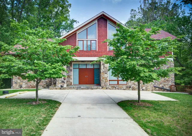 a front view of a house with a yard and trees