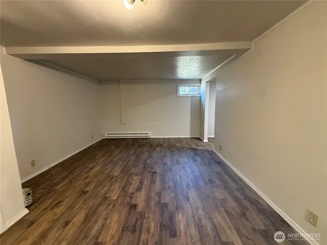 a view of a room with wooden floor and white walls