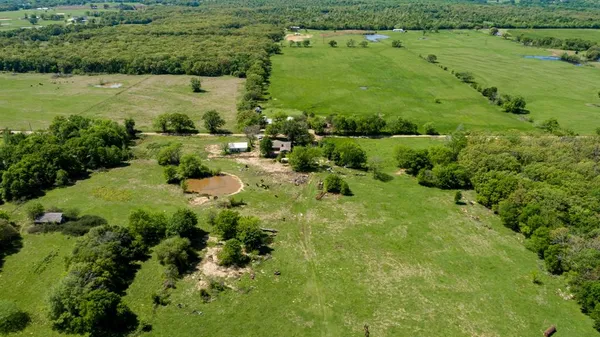 an aerial view of residential houses with outdoor space and trees