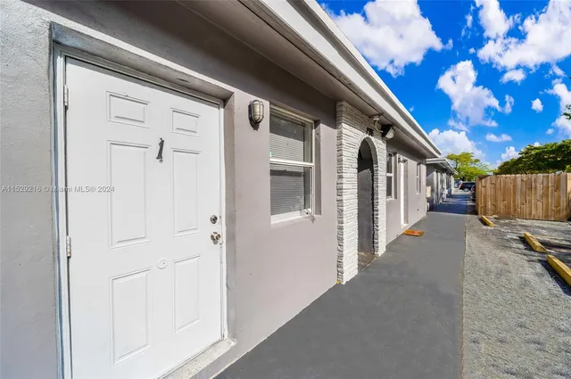 a view of a house with backyard and wooden fence