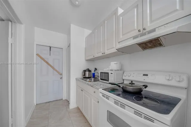 a kitchen with stainless steel appliances granite countertop a sink and a white cabinets