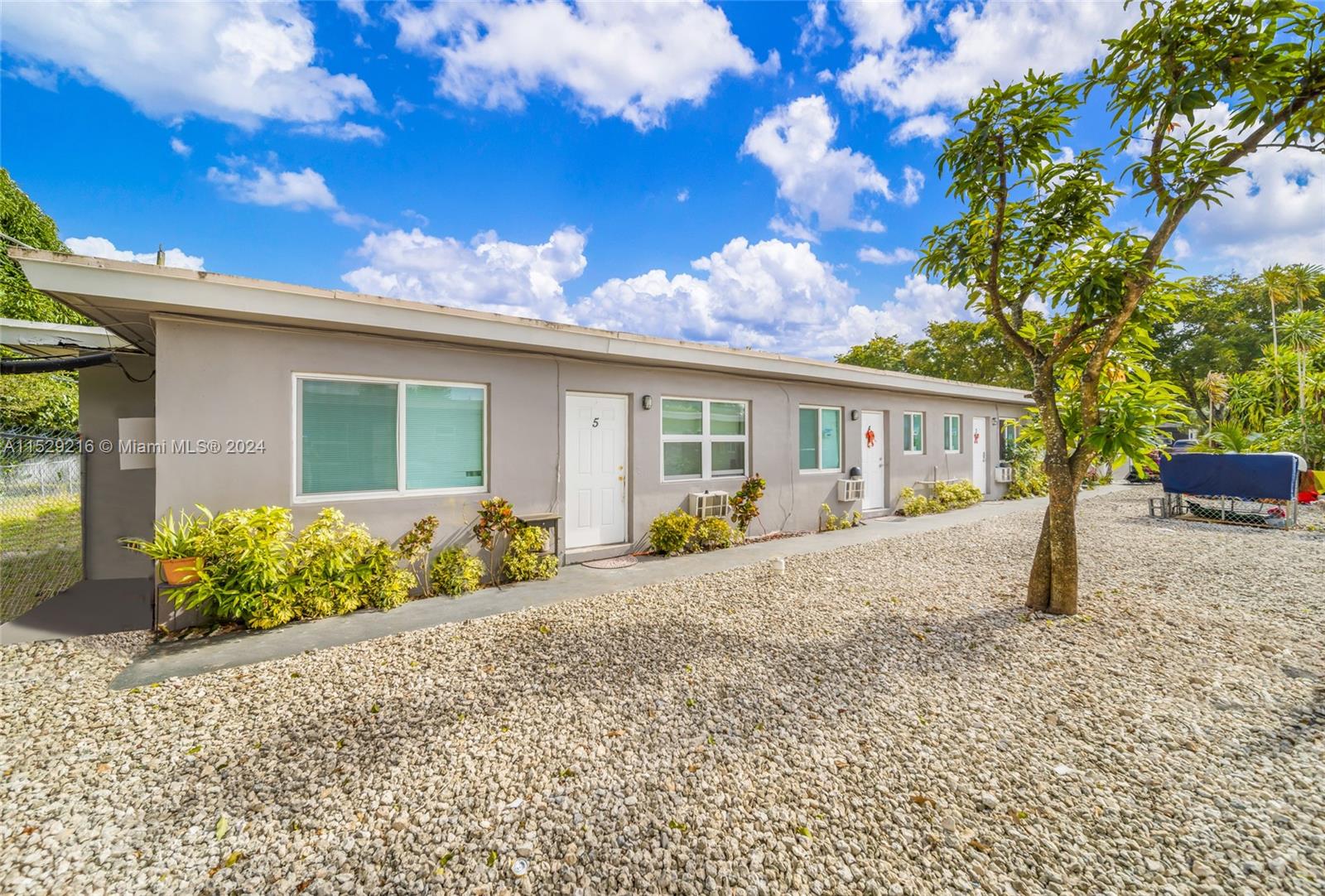 1219 Sharazad Boulevard Opa-Locka, FL 33054 - Photo 16 of 16 a front view of a house with a yard and potted plants