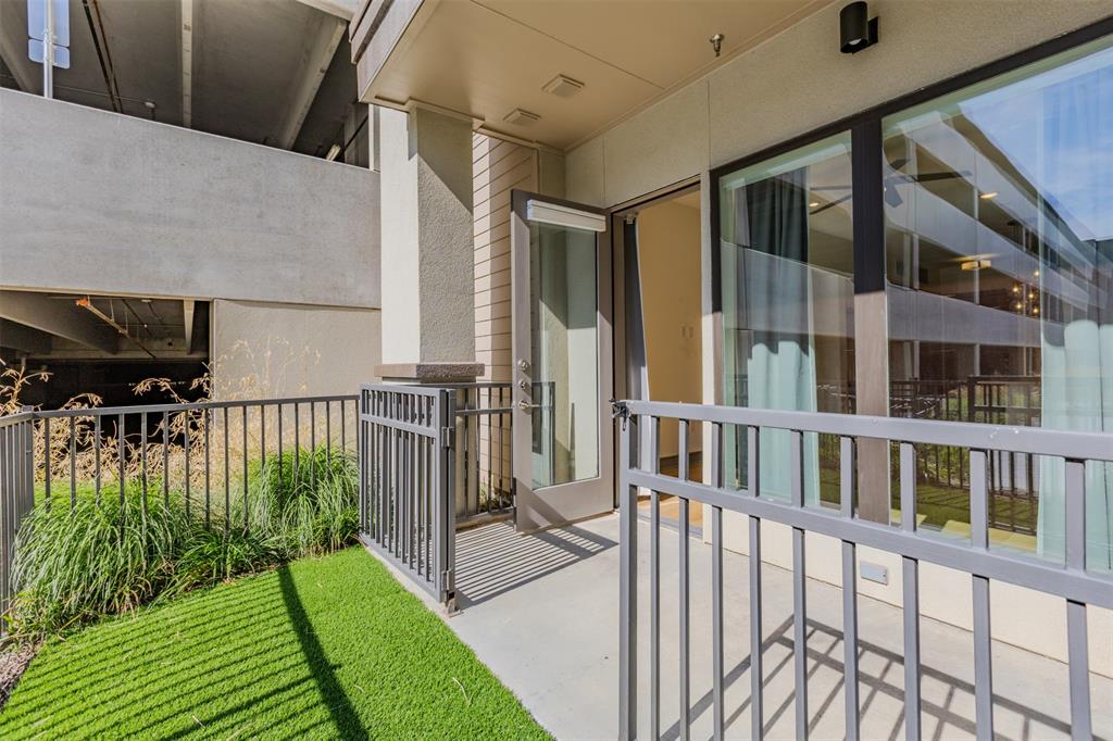 2700 Old Denton Road, Unit 1044 Carrollton, TX 75007 - Photo 19 of 33 Outdoor patio space featuring a concrete surface, a black metal railing, and an artificial turf area