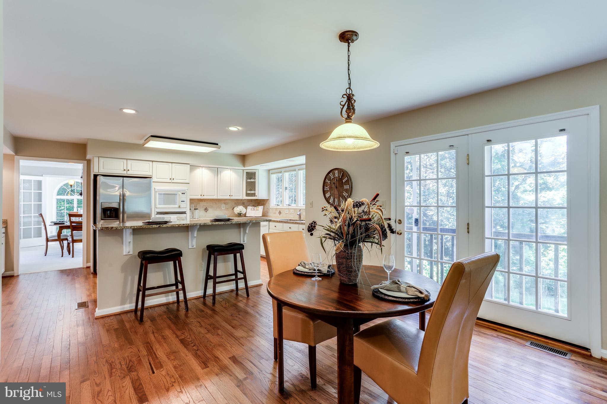 8258 Spring Branch Court Laurel, MD 20723 - Photo 11 of 26 a view of a dining room and livingroom with furniture wooden floor a chandelier