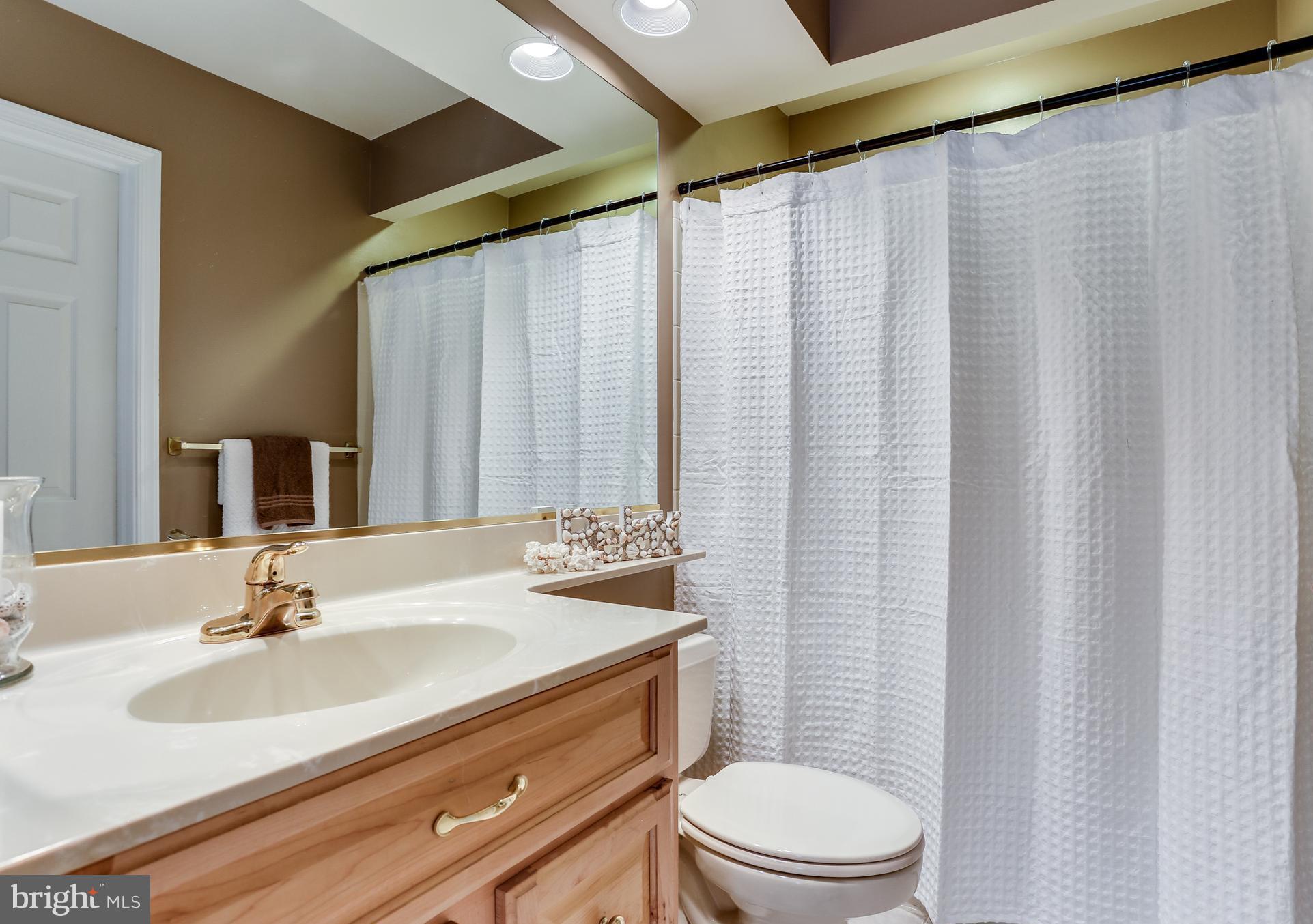 8258 Spring Branch Court Laurel, MD 20723 - Photo 14 of 26 a bathroom with a sink toilet and shower
