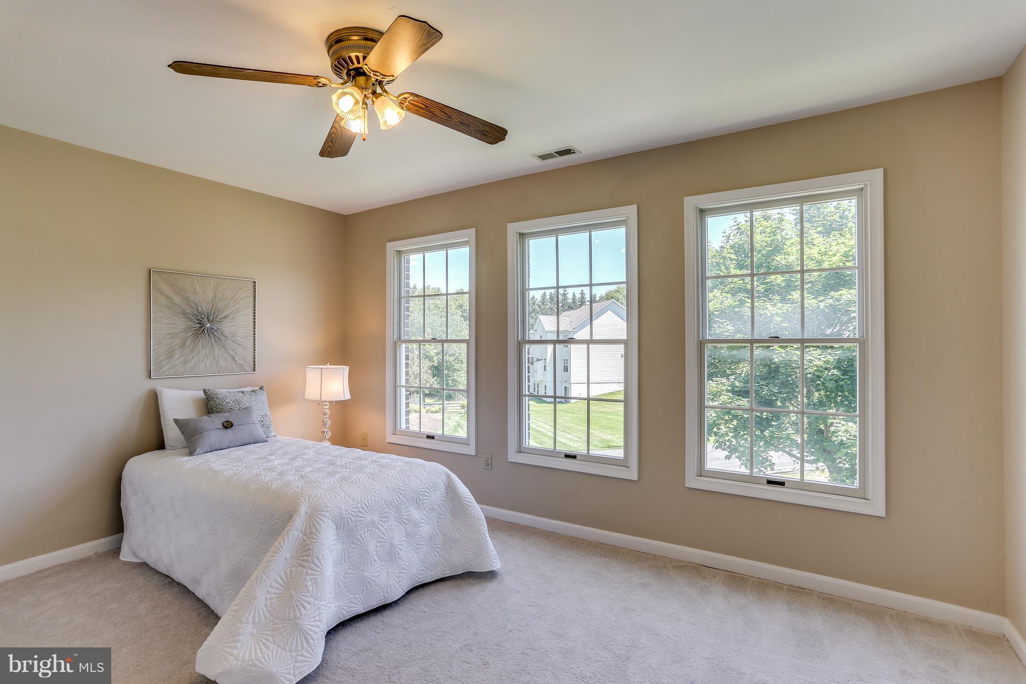 8258 Spring Branch Court Laurel, MD 20723 - Photo 20 of 26 a bedroom with a large bed and a chandelier fan