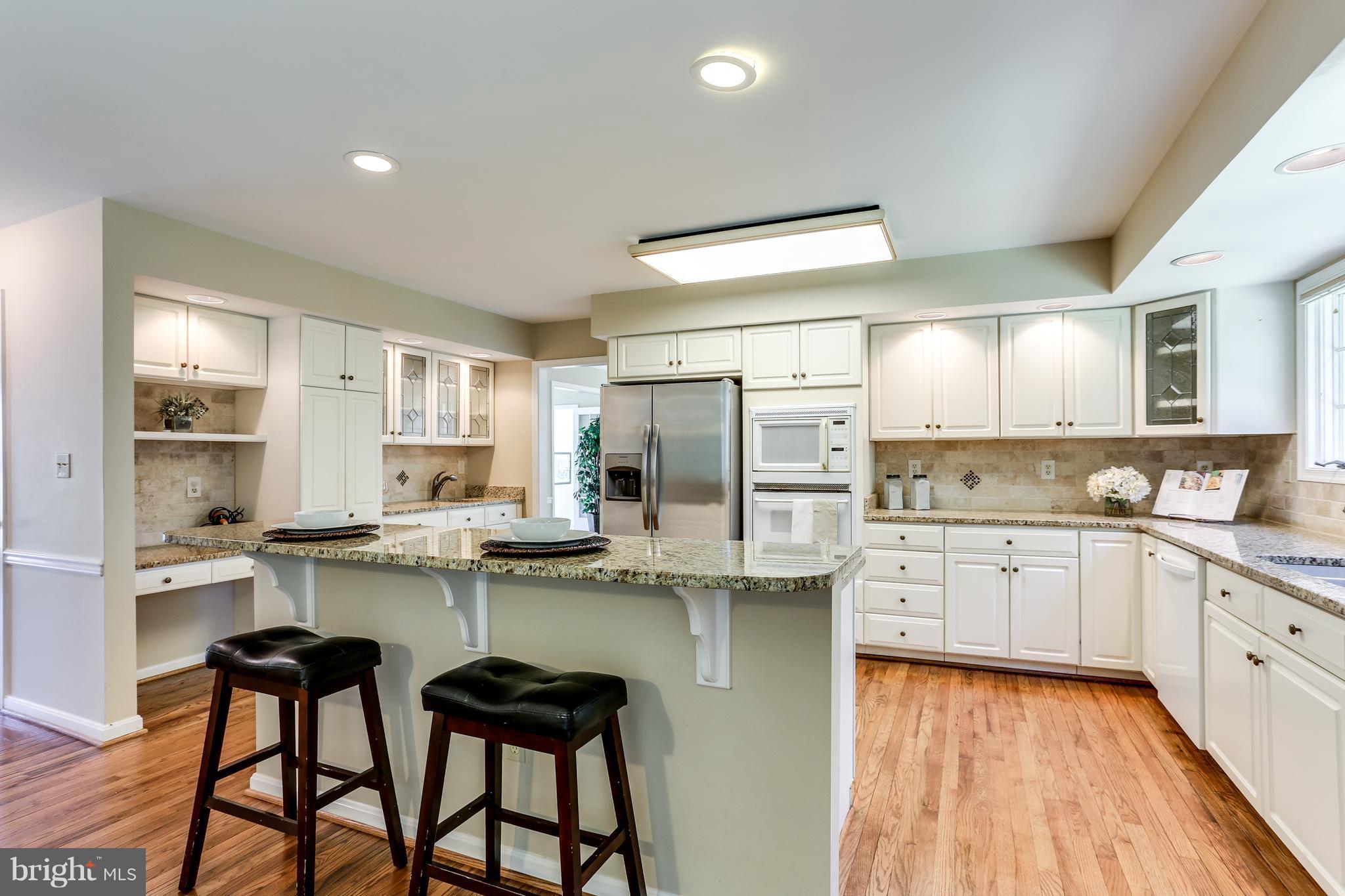 8258 Spring Branch Court Laurel, MD 20723 - Photo 8 of 26 a kitchen with sink a stove and chairs