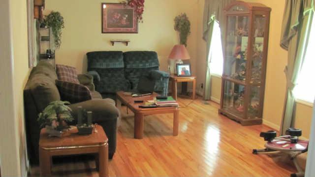 80 Maple Road Huntland, TN 37345 - Photo 2 of 12 Large great room offers gleaming hardwood floors, ceiling fan, and warm neutral paint color.