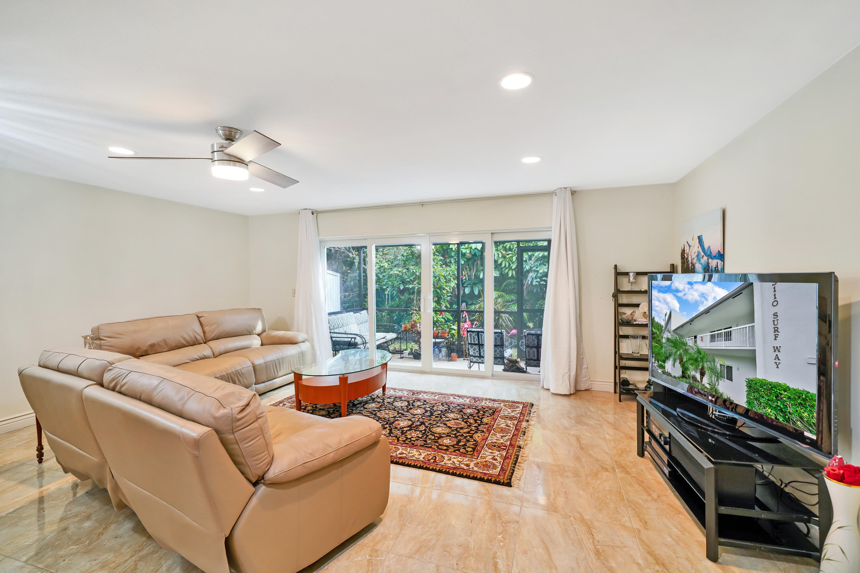 3110 Surf Way, Unit 2 Singer Island, FL 33404 - Photo 4 of 15 a living room with furniture and a flat screen tv