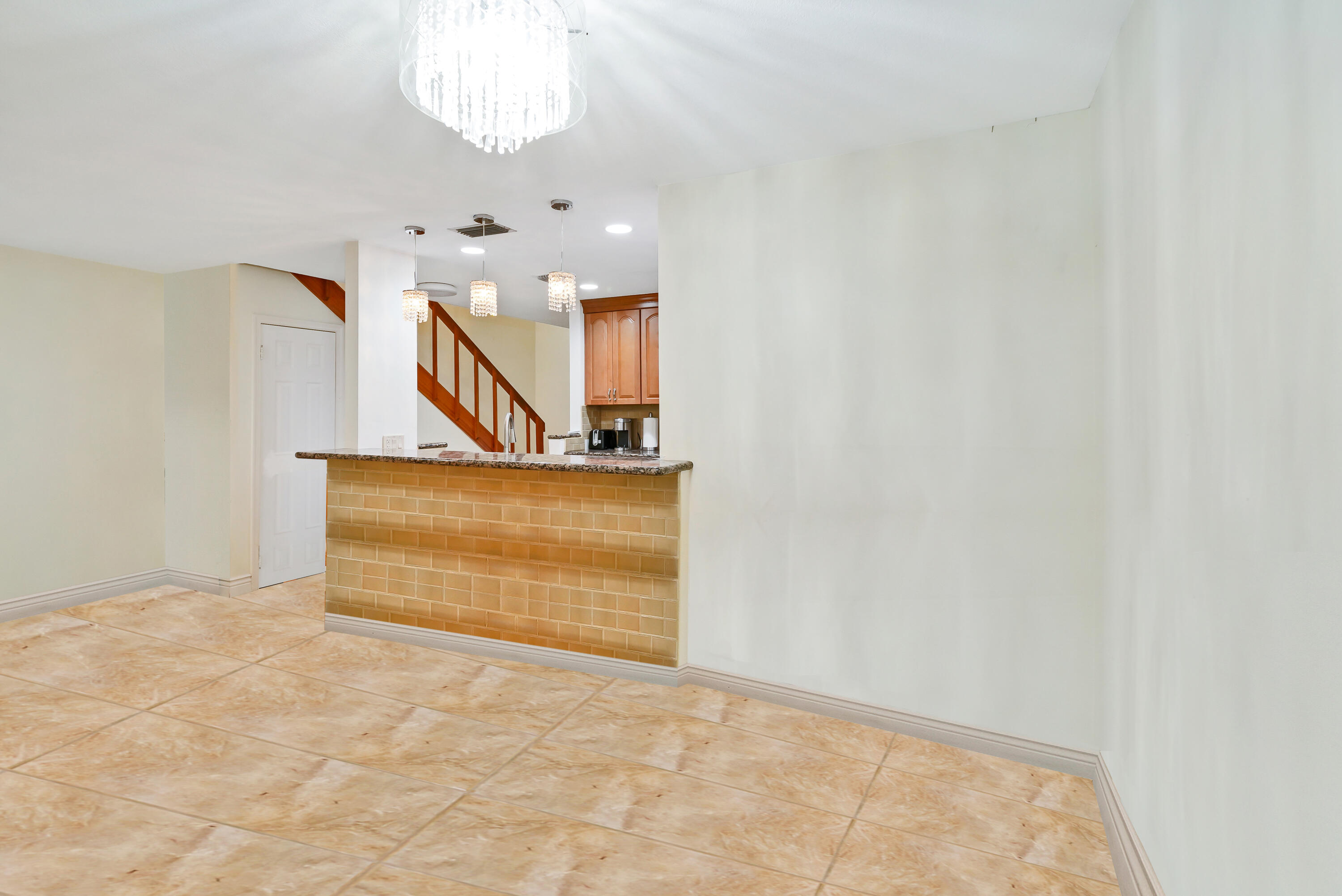 3110 Surf Way, Unit 2 Singer Island, FL 33404 - Photo 8 of 15 a view of a hallway with a chandelier and a window