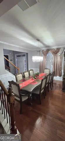 a dining room with furniture and wooden floor