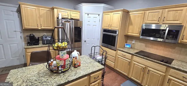 a kitchen with stainless steel appliances granite countertop a sink refrigerator and microwave