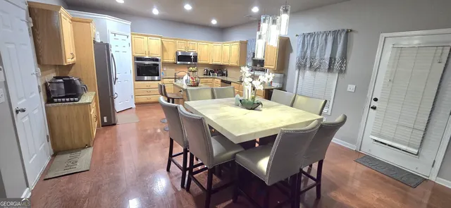 a view of a dining room with furniture a kitchen and chandelier