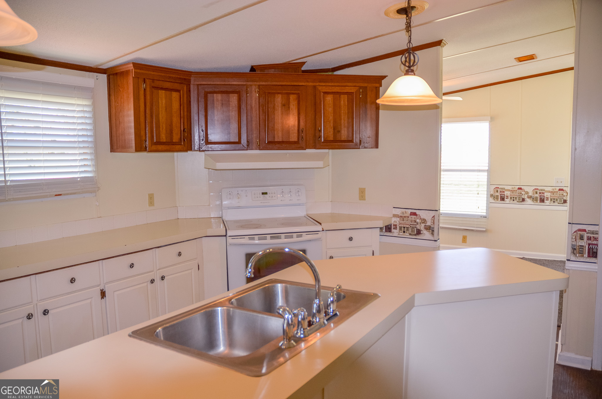 2055 Payne Pond Road Weston, GA 31832 - Photo 6 of 20 a kitchen with sink a window and chairs