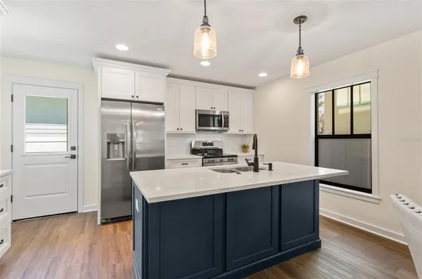 a kitchen with sink a refrigerator and a stove