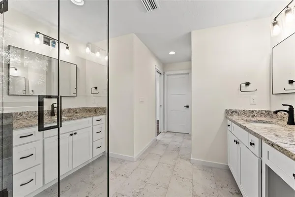 a spacious bathroom with a granite countertop sink mirror and shower
