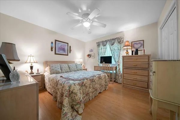a bedroom with a bed and a flat tv screen on dresser