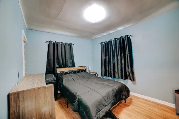 a bedroom with a bed and a wooden floor