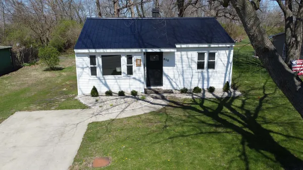 a view of a house with backyard and sitting area