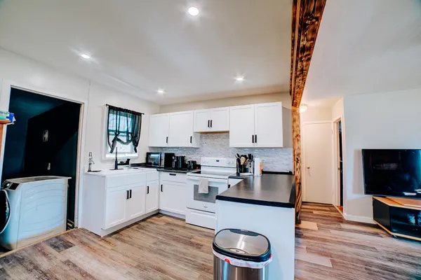 a kitchen with white cabinets and appliances