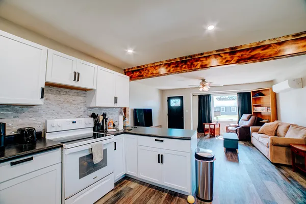 a kitchen with stainless steel appliances white cabinets a sink and a stove