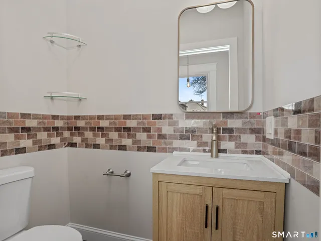 a bathroom with a sink a toilet and mirror