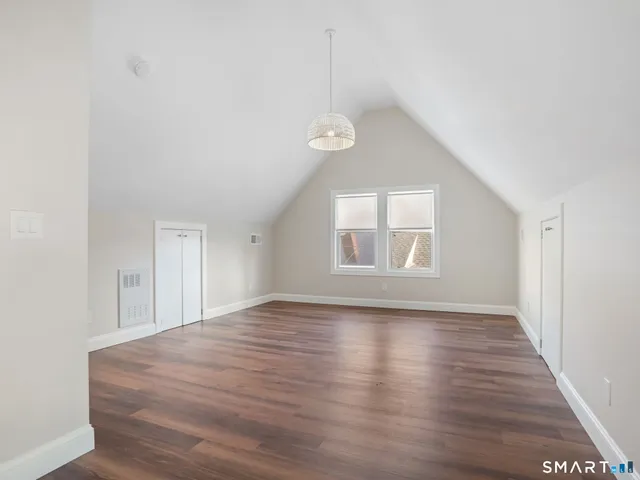 a view of empty room with wooden floor
