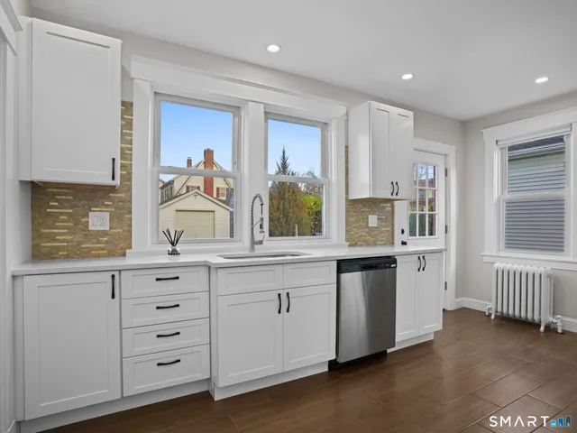 a kitchen with granite countertop white cabinets and white appliances