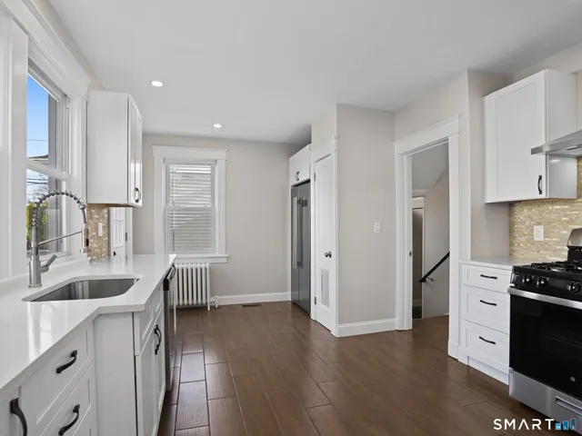a kitchen with granite countertop a sink stove and refrigerator