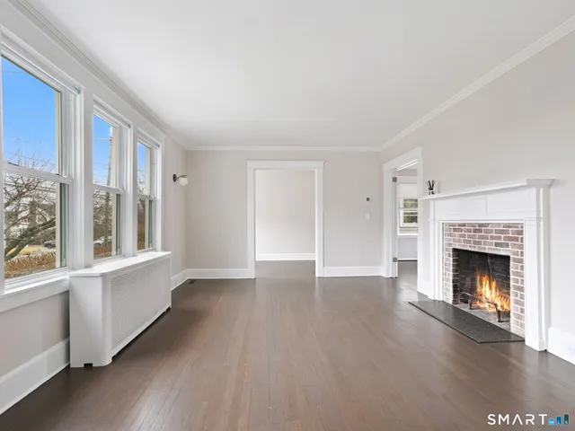wooden floor fireplace and windows in an empty room