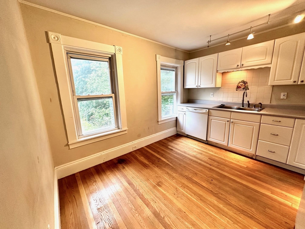 6 Grant Street, Unit 2 Natick, MA 01760 - Photo 2 of 15 a kitchen with wooden floors and wide window
