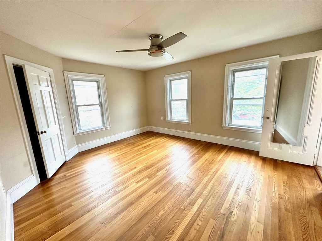 6 Grant Street, Unit 2 Natick, MA 01760 - Photo 5 of 15 a view of empty room with wooden floor and fan