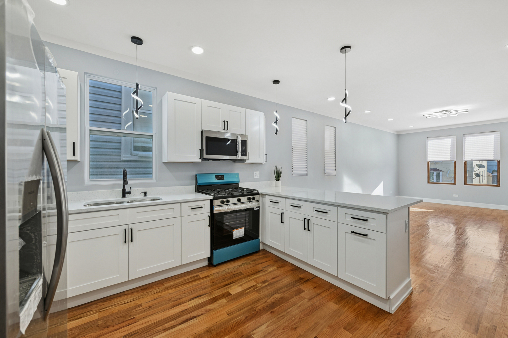 2536 West 46th Street Chicago, IL 60632 - Photo 12 of 21 a large kitchen with stainless steel appliances granite countertop a sink dishwasher a stove and a refrigerator with wooden floor