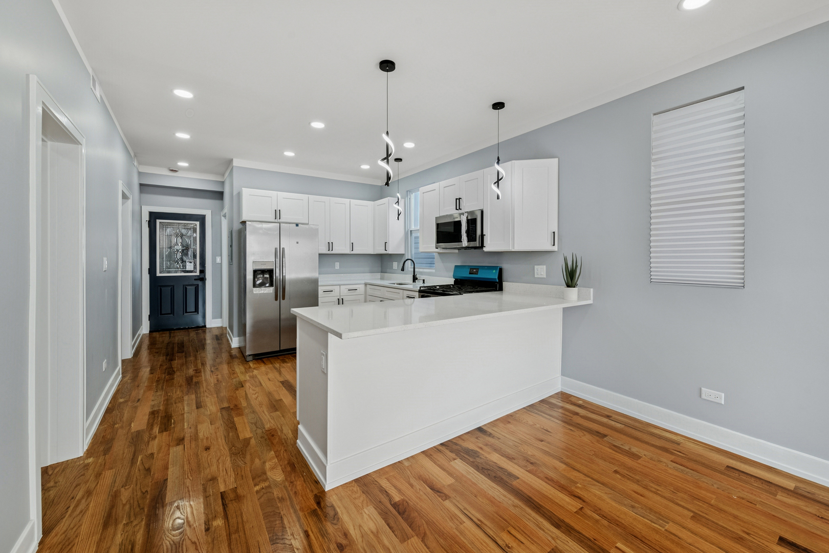 2536 West 46th Street Chicago, IL 60632 - Photo 10 of 21 a kitchen with wooden floor white cabinets and stainless steel appliances