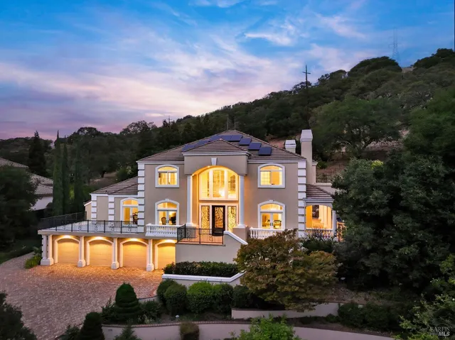 a large building with a clock tower in middle of a garden