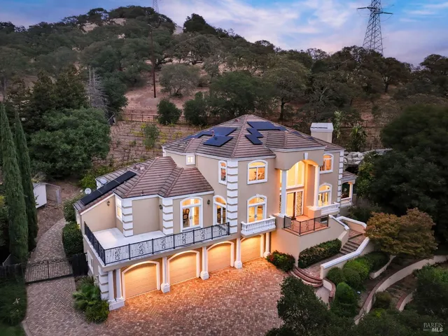 an aerial view of a house with swimming pool and mountains