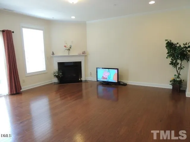 an empty room with windows and fireplace