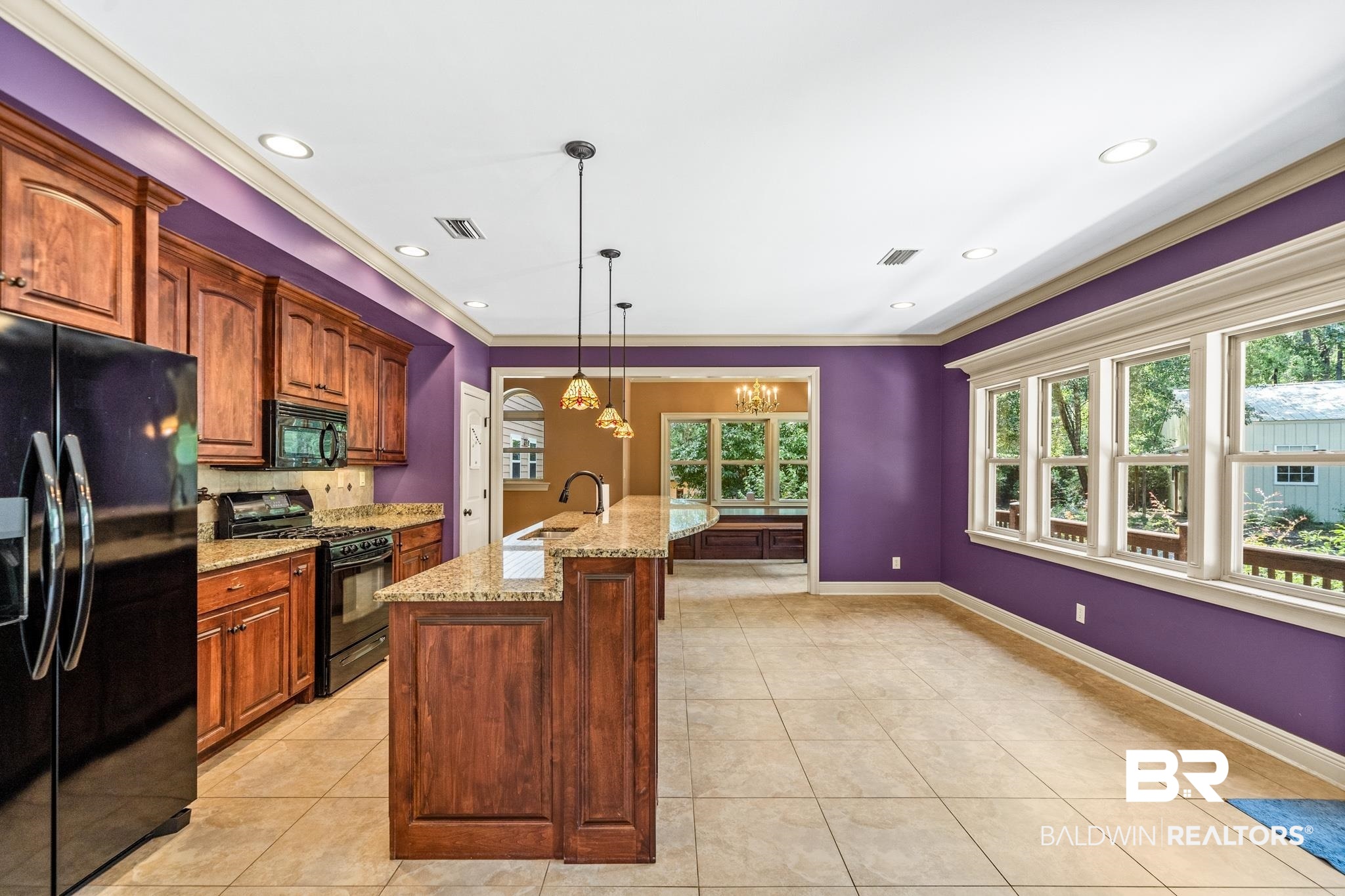 8321 Dixon Road Bay Minette, AL 36507 - Photo 24 of 79 Kitchen with light tile patterned floors, an island with sink, sink, black appliances, and decorative light fixtures