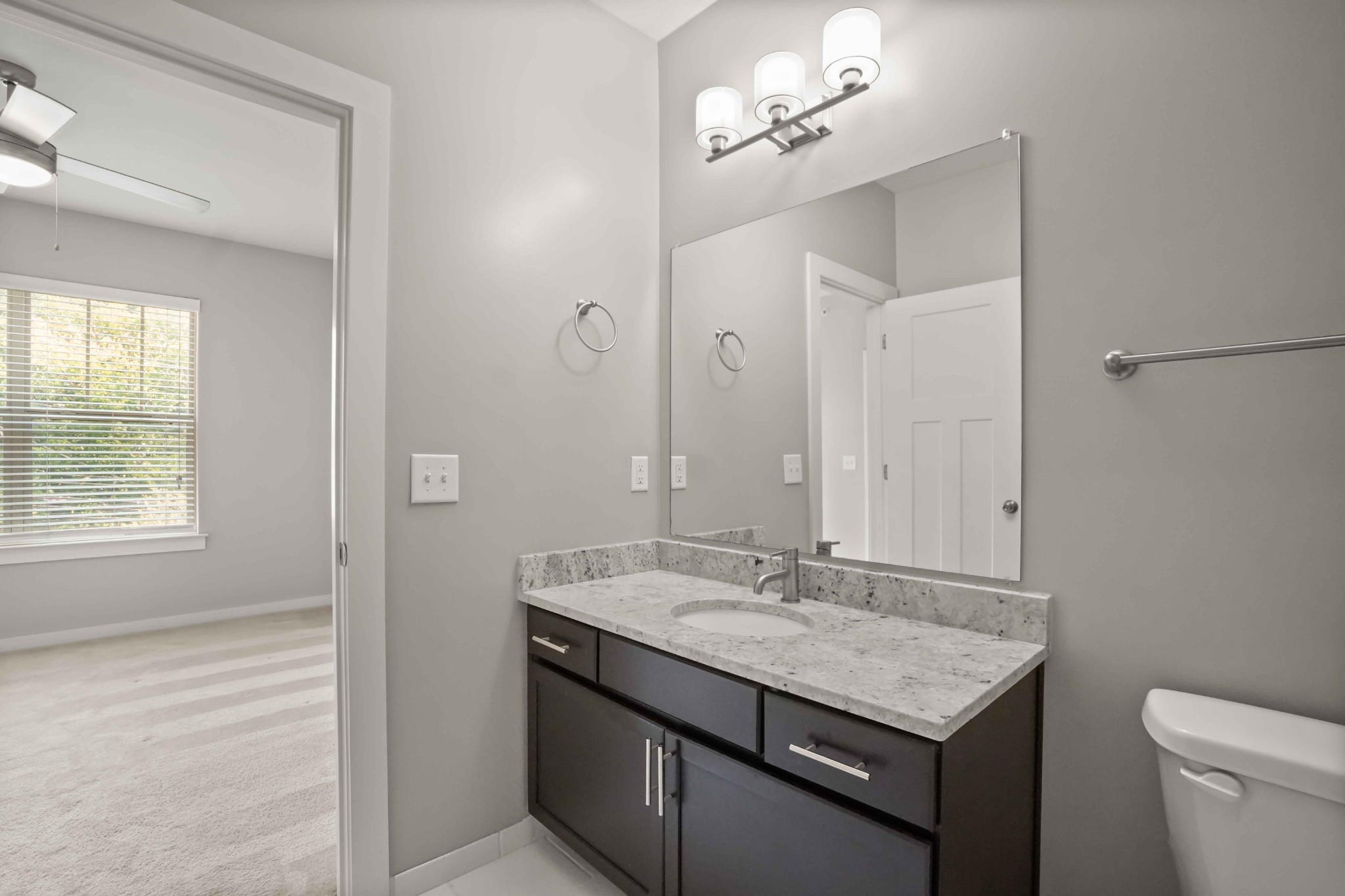 414 Rosedale Avenue, Unit 308 Nashville, TN 37211 - Photo 21 of 26 a bathroom with a granite countertop sink a toilet and a mirror